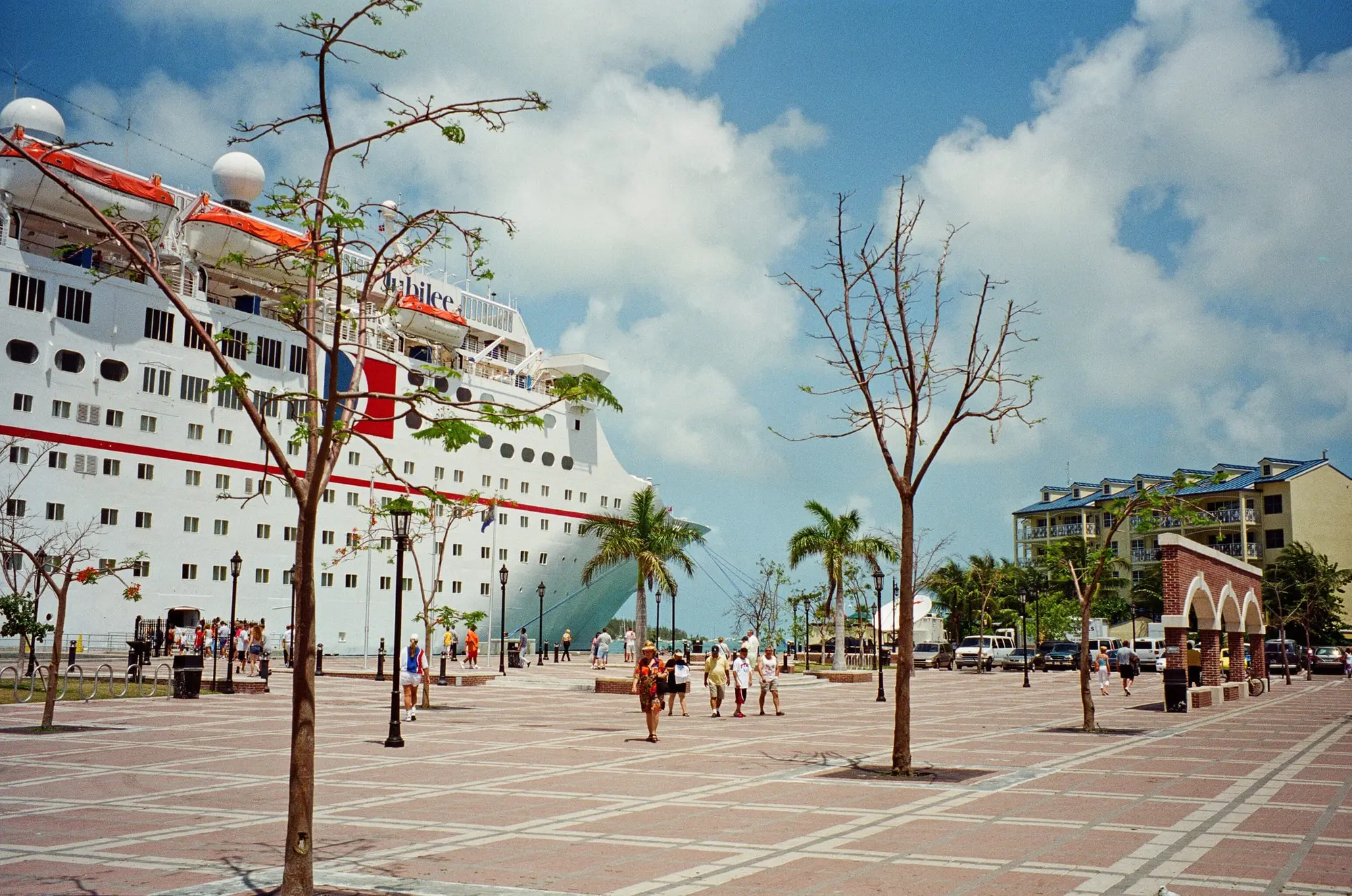 A cruise ship at the Key West docks beside a palm-planted plaza