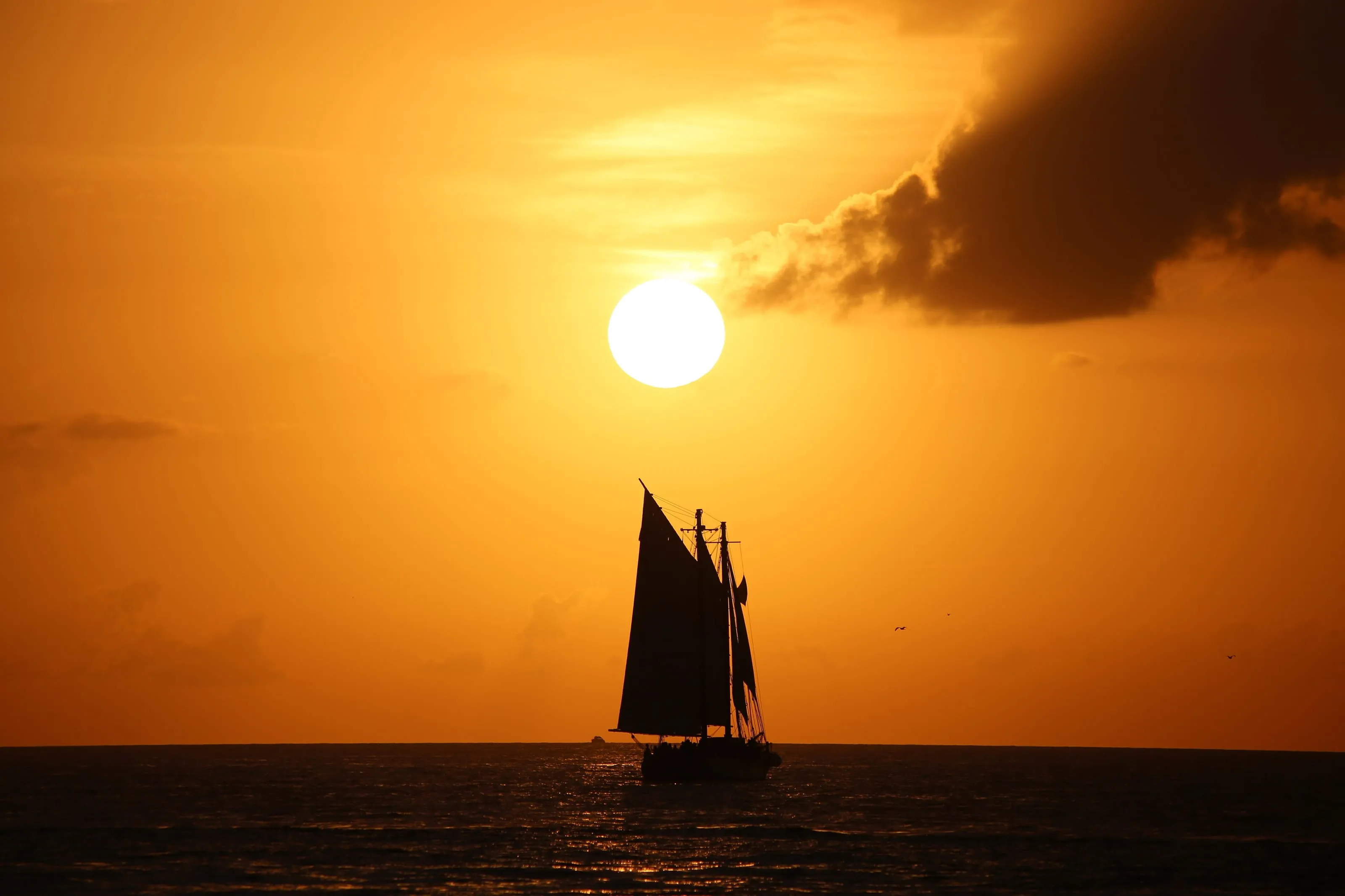 Sunset over the water at Key West, the sky going orange behind moored boats