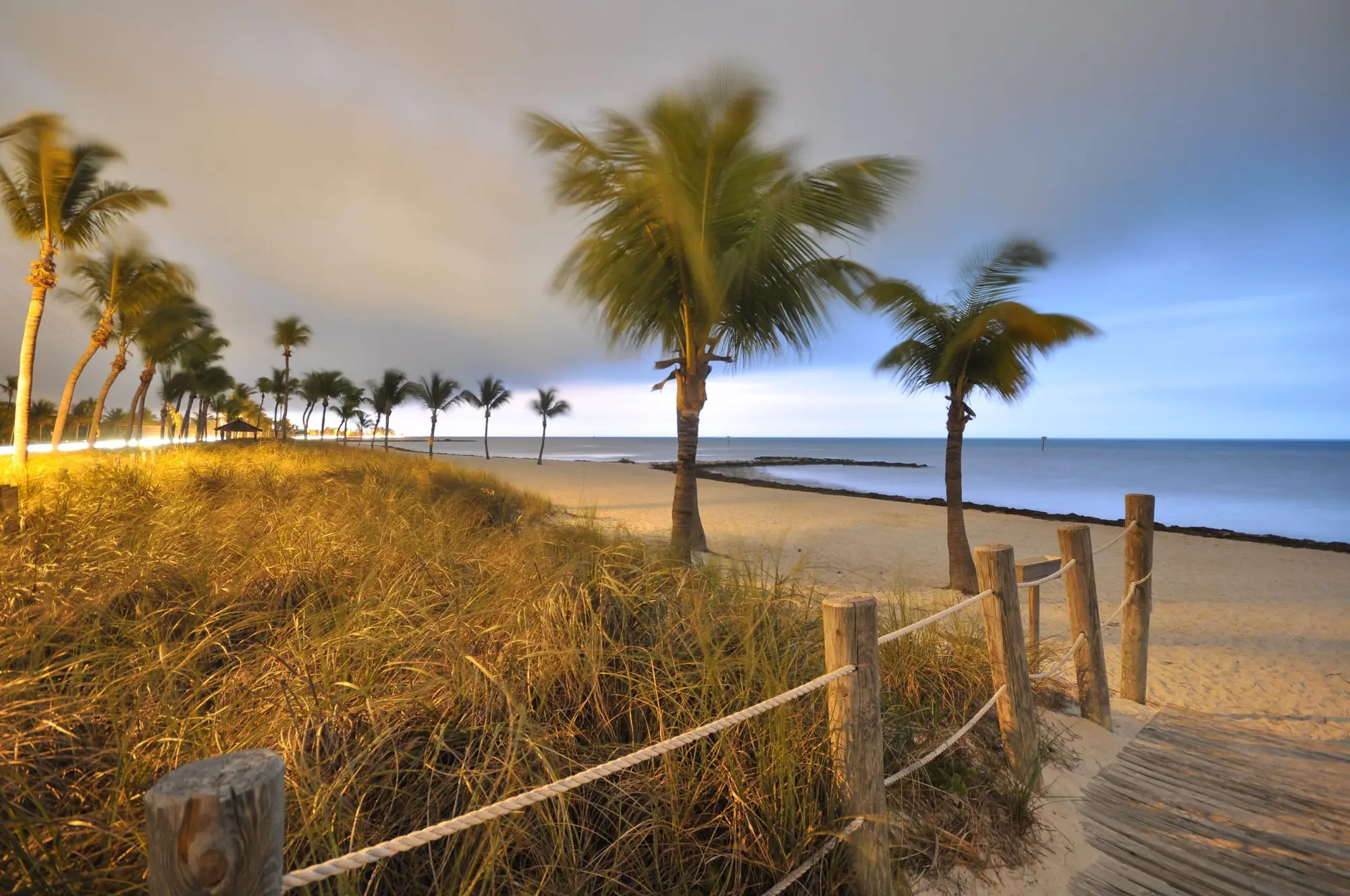 Smathers Beach in Key West before sunrise, palms along the sand as a storm approaches